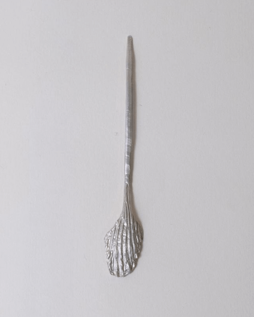 a silver spoon on a white surface from the brand cinque made